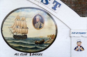 Wall paintings outside tattooist parlour underneath arches at Portsmouth Harbour railway station