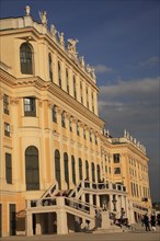 Schonnbrunn Palace. Part view of exterior facade with tourist visitors in courtyard and on steps