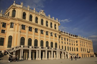 Schonnbrunn Palace. Part view of exterior facade with tourist visitors on flight of steps and in