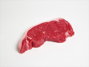 Slice of raw uncooked sirloin steak on a white background. Photo: Paul Seheult