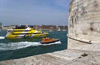 A Pilot boat and catamaran ferry entering the harbour between HMS Dolphin in Gosport and The Round