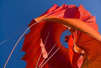 Close up of a section of a red and orange hot air balloon as it deflates. Photo : Hugh Rooney