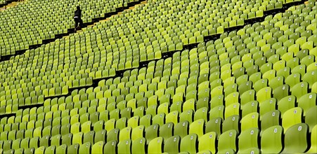 Olympic Stadium. Curved section of bright green seating in the stadium with standing figure at far