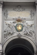 Inscription and sculpted figures above the Michaelertrakt gateway to the Hofburg Palace. Photo :