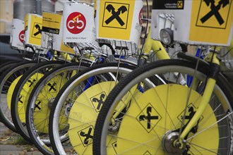 Cropped view of wheels of line of bicycles for public hire. Photo : Bennett Dean