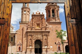 Mexico, Bajio, Zacatecas, Monastery and Church of Guadalupe seen through opening in entrance gates.
