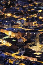 Mexico, Bajio, Zacatecas, View over the city rooftops illuminated at night from Cerro de la Buffa.