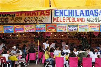 Mexico, Bajio, Zacatecas, Feria food stalls with customers eating on tables outside. 
Photo : Nick