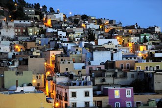 Mexico, Bajio, Zacatecas, Colourful houses on hillside illuminated at night. 
Photo : Nick Bonetti