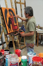 Mexico, Bajio, San Miguel de Allende, Artist Juan Ezcurdia in his studio working on painting set on