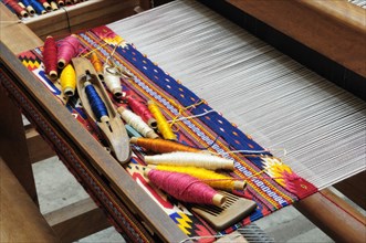 Mexico, Oaxaca, Spools of coloured wools on loom ready for weaving. 
Photo : Nick Bonetti