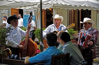 Mexico, Bajio, Guanajuato, Mariachi musicians playing at cafe in Jardin de la Union. 
Photo : Nick