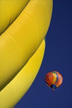 USA, New Mexico, Albuquerque, Annual balloon fiesta colourful hot air balloons ascending with part