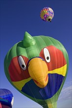 USA, New Mexico, Albuquerque, Annual balloon fiesta colourful hot air balloons with parrot shaped
