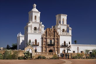 USA, Arizona, Tucson, Mission Church of San Xavier del Bac. Exterior facade with visitors at