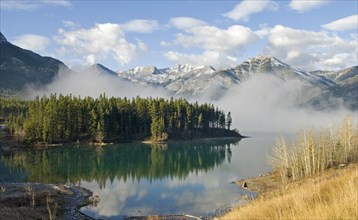 Canada, Alberta, Kananaskis, Early morning mist rising from Barrier Lake with Heart Mountain and