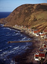 Scotland, Aberdeenshire, Crovie, One time fishing village seen from cliff top. Row of cottages at