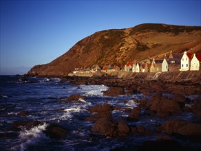 Scotland, Aberdeenshire, Crovie, One time fishing village seen from shoreline. Row of cottages at