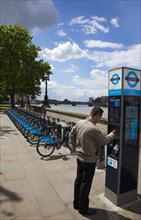 England, London, Vauxhall Albert Embankment of the river Thames man buying time on bicycle hire