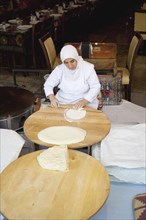 Turkey, Istanbul, Sultanahmet woman rolling out bread dough in restaurant. 
Photo : Stephen