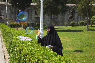 Turkey, Istanbul, Istanbul Sultanahmet woman selling bubble gun machine in park outside the Blue