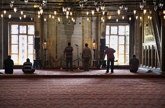Turkey, Istanbul, Sultanahmet Camii Blue Mosque interior with men at worship. 
Photo : Stephen