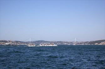 Turkey, Istanbul, Eminonu view of the Bosphorus bridge with ferries passing in the foreground.