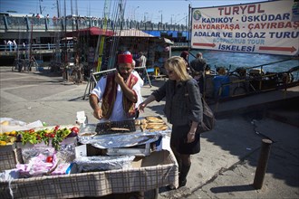Turkey, Istanbul, Karakoy Galata fish market man selling freshly grilled fish served in a bread
