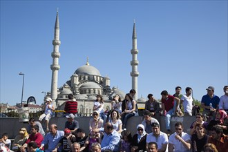 Turkey, Istanbul, Eminonu Yeni Camii New Mosque people on sat on steps next to the subway. Stephen