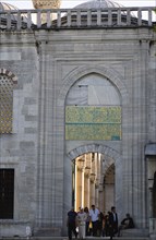 Turkey, Istanbul, Sultanahmet Camii The Blue Mosque with people passing through the entrance to the