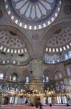 Turkey, Istanbul, Sultanahmet Camii The Blue Mosque interior with people at prayer beneath