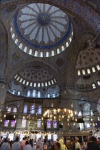 Turkey, Istanbul, Sultanahmet Camii The Blue Mosque interior with sightseeing tourists by a