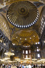 Turkey, Istanbul, Sultanahmet Haghia Sophia Sightseeing tourists beneath the dome with murals and