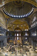 Turkey, Istanbul, Sultanahmet Haghia Sophia Sightseeing tourists beneath the dome with murals and