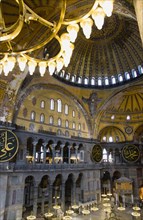 Turkey, Istanbul, Sultanahmet Haghia Sophia Sighseeing tourists beneath the dome with murals and