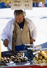 Turkey, Istanbul, Sultanahmet Man selling roast chestnuts and sweetcorn in the street. 
Photo :