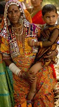 PORTRAIT OF A LAMBANI GYPSY TRIBAL WOMAN AND CHILD WITH TRADITIONAL TRIBAL JEWELRY AND COSTUME, INDIA. (MR)