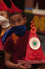 Student Buddhist Lama Novice carrying a wax art piece in a Losar ceremony, Sikkim, India