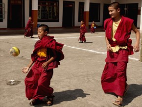 Buddhist student monks playing soccer or football at a monastery in Sikkim, India