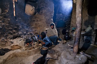 Ethiopia, People, Inside a rural house with women cooking by open fire fueled by animal dung.