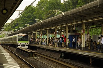 Japan, Honshu, Tokyo, Commuters train arriving at station platform. 
Photo : Jon Burbank