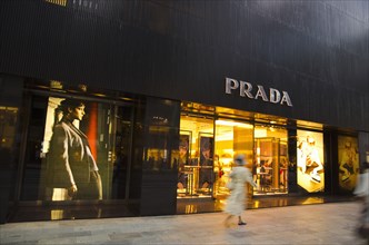 Japan, Honshu, Tokyo, Ginza shopper walking by the Prada store on Chou-dori Avenue. 
Photo : Jon