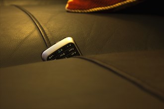 Communications, Telephones, Mobile, Phone stuck between cushions of leather sofa. 
Photo : Stephen