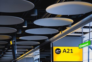 England, London, Heathrow Airport Terminal 5 disc ceiling in departures zone with passengers