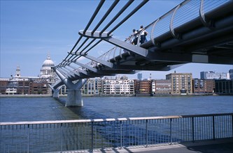 View along the Millennium footbridge over the river Thames toward St Pauls Cathedral and city.