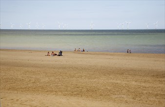 Wind Farm offshore on the horizon showing turbine blades.