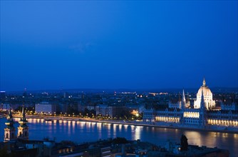 Buda Castle District: view over Danube and Pest with Parliament Building illuminated.