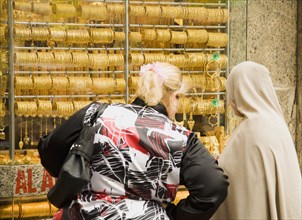 Women one veiled shop for gold jewellery in window display of Gold Souk Deira.