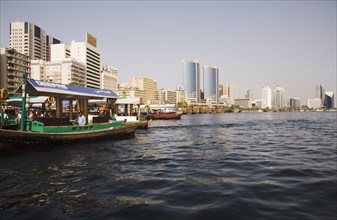 Abra water taxi moored on the Creek with Twin Towers shopping mall and skyline behind.