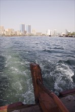 Abra water taxi view from rudder across the Creek with Twin Towers shopping mall and skyline behind.